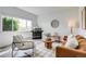 Cozy living room with a fireplace, comfortable seating, a large window, and stylish decor at 2642 Devonshire Ct, Denver, CO 80229