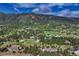 Expansive aerial shot displaying homes surrounded by lush green trees and mountain views at 18376 Heavens Pl, Monument, CO 80132