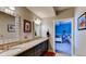 Bathroom featuring dual sinks with a shared granite countertop and adjoined room at 18376 Heavens Pl, Monument, CO 80132