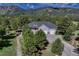 Aerial view of the front of the house, with a three-car garage and mature trees at 18376 Heavens Pl, Monument, CO 80132