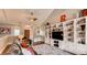 Comfortable living room with built-in shelving, a ceiling fan, and wood floors at 18376 Heavens Pl, Monument, CO 80132