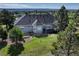 Aerial view of the home's rear exterior, with a deck overlooking a manicured lawn at 18376 Heavens Pl, Monument, CO 80132