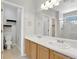Bright bathroom featuring double sinks, framed mirror, tiled floors, and a separate toilet room at 971 Parsons Ave, Castle Rock, CO 80104