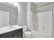 Bathroom features a large mirror, vanity with black cabinets, and bathtub with shower at 971 Parsons Ave, Castle Rock, CO 80104