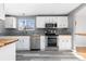 Bright kitchen featuring white cabinets, butcher block counters, stainless steel appliances, and gray tile backsplash at 6203 W 95Th Ave, Westminster, CO 80031