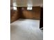 Spacious basement with wood paneling and concrete floor, ready for renovation at 8250 Ralph Ln, Denver, CO 80221