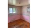 Bedroom with wood floor, light pink walls with unicorn wallpaper border and natural lighting from two windows at 8250 Ralph Ln, Denver, CO 80221