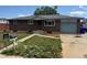 Charming single-story brick home with a tidy yard and driveway leading to a one-car garage at 8250 Ralph Ln, Denver, CO 80221