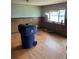 Living room with wood paneling, wood floors, large windows, and a large trash can at 8250 Ralph Ln, Denver, CO 80221