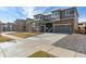 Two-story home with gray siding, stone accents, and a two-car garage in a new development at 1749 Marlowe E Cir, Erie, CO 80516