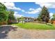 Beautiful backyard featuring a green lawn, mature trees, partial fencing, and a storage shed at 1354 S Wright St, Lakewood, CO 80228