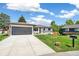 Charming single-story home showcasing a manicured lawn, mature trees, long driveway, and a gray garage door at 1354 S Wright St, Lakewood, CO 80228
