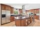 Bright kitchen features stainless steel appliances, light wood floors, dark countertops and a large center island with gas cooktop at 1354 S Wright St, Lakewood, CO 80228