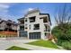 Modern exterior featuring a bright white facade, black trim, balconies, flower boxes, and a well-manicured front lawn at 2522 Zenobia St, Denver, CO 80212