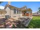 Backyard with covered patio and stone terrace with view of the house exterior at 11506 Greenbriar Ln, Parker, CO 80138