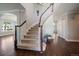 Grand foyer featuring a curved staircase with wood railing and hardwood floors at 11506 Greenbriar Ln, Parker, CO 80138