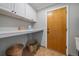 Functional laundry area with built-in shelving, storage cabinets, and convenient outside access at 11506 Greenbriar Ln, Parker, CO 80138