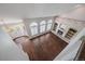 Sunlit living room featuring wood floors, large arched windows, and a cozy brick fireplace at 11506 Greenbriar Ln, Parker, CO 80138