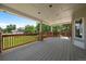 Covered deck area with wooden railing, pillars, and view of yard and neighborhood at 11506 Greenbriar Ln, Parker, CO 80138