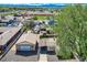 This aerial view displays the property featuring a detached garage, multiple storage sheds, and a fenced-in yard at 4835 Harlan St, Wheat Ridge, CO 80033