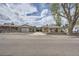 The exterior of the single story home with detached garage and gravel yard from across the street at 4835 Harlan St, Wheat Ridge, CO 80033