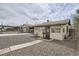The front exterior of this tan home, is a single story with a covered car port and gravel yard at 4835 Harlan St, Wheat Ridge, CO 80033