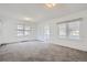 Spacious living room with neutral carpet, white walls, and natural light from multiple windows at 4835 Harlan St, Wheat Ridge, CO 80033