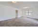 Bright living room with neutral carpet, white walls, and open doorway to another room at 4835 Harlan St, Wheat Ridge, CO 80033