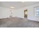 Open-concept living room with neutral carpet, white walls, and views into the kitchen and other rooms at 4835 Harlan St, Wheat Ridge, CO 80033