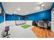 Finished basement with blue accent wall, workout equipment, and a computer desk area at 2019 Clipper Dr, Lafayette, CO 80026