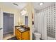 Cozy bathroom featuring a double vanity, shower with black and white tile, and neutral walls at 2019 Clipper Dr, Lafayette, CO 80026