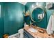 Stylish powder room featuring unique textured walls, round mirror, designer fixtures, and granite countertop with an elegant sink at 2019 Clipper Dr, Lafayette, CO 80026