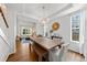 Open-concept dining room with rustic wood table, bench seating, modern chandelier, and hardwood floors that flow into the living room at 2019 Clipper Dr, Lafayette, CO 80026