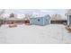 Snowy backyard featuring a small shed, wood fence, and gardening boxes at 1825 S Adams St, Denver, CO 80210