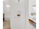 Hallway view of an updated bathroom with subway tile and a charming bedroom with wood floors at 1825 S Adams St, Denver, CO 80210