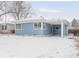 Side view of a blue single-story home with carport and snow covered ground at 1825 S Adams St, Denver, CO 80210