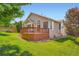 Well-maintained backyard featuring a wooden deck, lush lawn, and mature trees, perfect for outdoor relaxation at 22436 E Maplewood Pl, Aurora, CO 80015