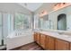 Bright bathroom with a large soaking tub, dual sinks, and a separate shower at 22436 E Maplewood Pl, Aurora, CO 80015