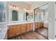 Bright bathroom featuring a double sink vanity with wood cabinets and a large mirror at 22436 E Maplewood Pl, Aurora, CO 80015