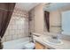 Tiled bathroom featuring a shower-tub combination with decorative tile at 22436 E Maplewood Pl, Aurora, CO 80015