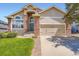 Charming home features a well-manicured lawn, brick accents, and an attached two-car garage at 22436 E Maplewood Pl, Aurora, CO 80015