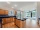 Charming kitchen boasts wood cabinets, black countertops, and hardwood floors at 22436 E Maplewood Pl, Aurora, CO 80015