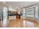 Sunlit kitchen with a stainless steel refrigerator, hardwood floors, and a large window at 22436 E Maplewood Pl, Aurora, CO 80015