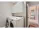 Laundry room features white washer, dryer, and overhead storage at 22436 E Maplewood Pl, Aurora, CO 80015