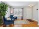 Bright living room with hardwood floors, comfy chairs, and a large window at 5885 Cheetah Cv, Lone Tree, CO 80124