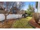 Professionally landscaped backyard with a fountain, lush lawn, stone pathway, and mature trees at 742 Megan Ct, Longmont, CO 80504