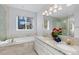 Well-lit bathroom with double sinks, granite countertops, soaking tub, and a large window, creating a luxurious space at 742 Megan Ct, Longmont, CO 80504