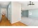 Bright hallway with hardwood floors leads to a spacious living area with neutral carpet and modern lighting at 742 Megan Ct, Longmont, CO 80504