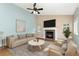 Cozy living room featuring a fireplace, ceiling fan, comfortable seating, and natural light from the windows at 742 Megan Ct, Longmont, CO 80504