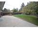 Large concrete patio overlooks a peaceful fenced back yard with mature trees at 8450 Mason Cir, Westminster, CO 80031